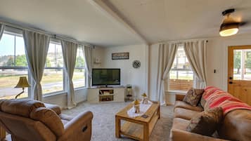 Ein Wohnzimmer mit Fernseher, Sofa und Couchtisch.