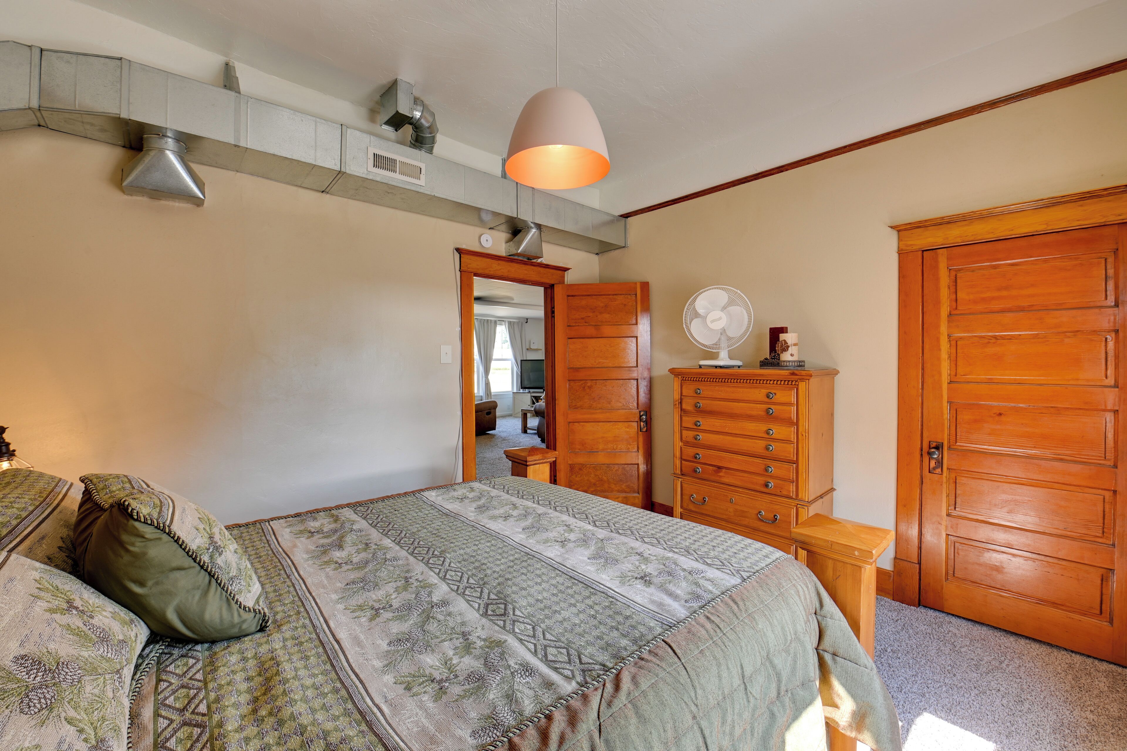 Une chambre à coucher avec un lit, une commode et une armoire en bois.