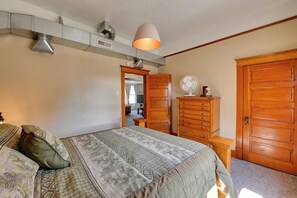 Une chambre à coucher avec un lit, une commode et une armoire en bois.