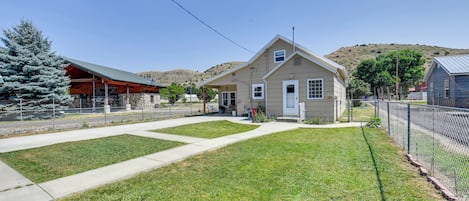 A residential property with a front yard, a house, and a building with a sign.