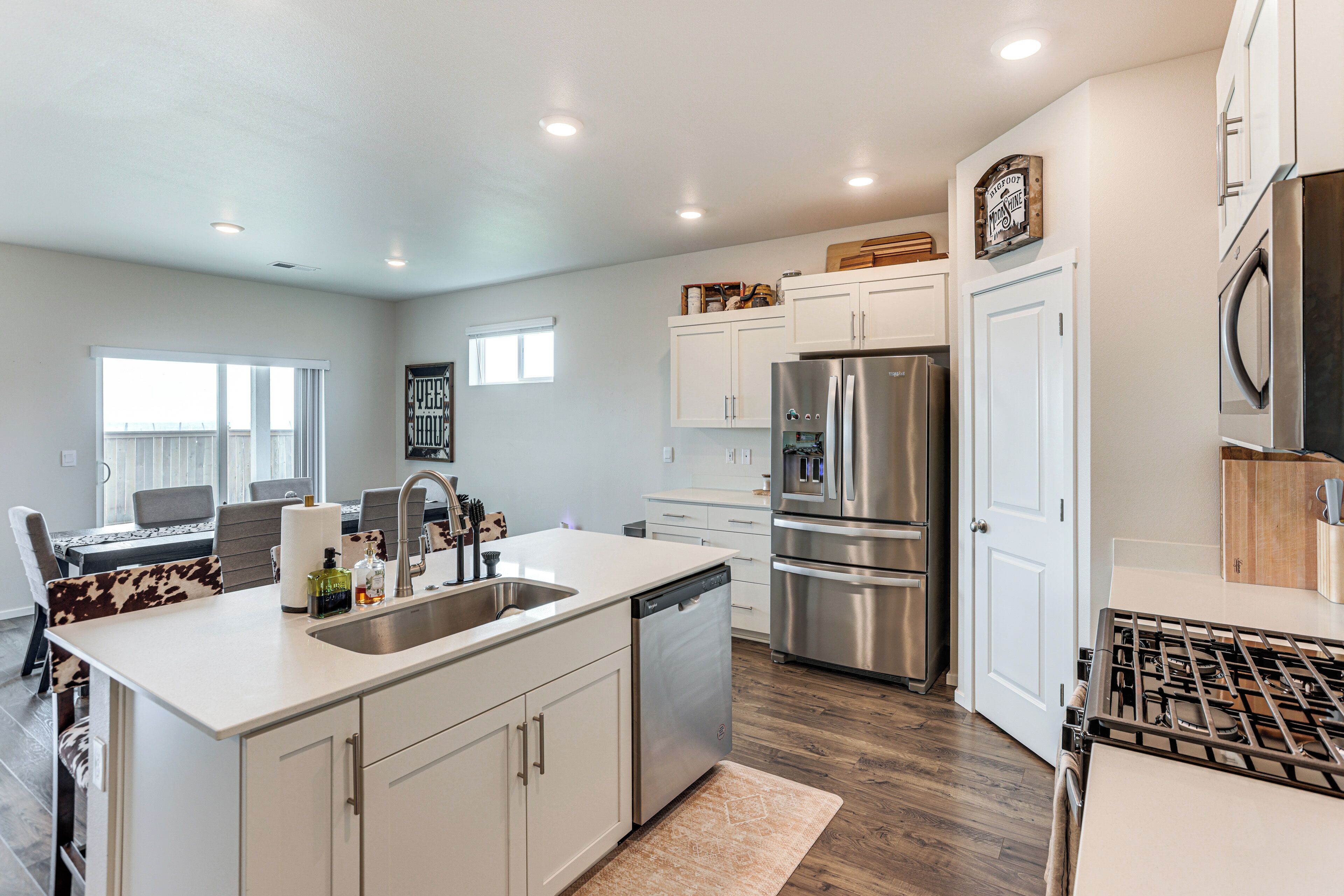 A modern kitchen with a stainless steel refrigerator, a dishwasher, and a gas stove.