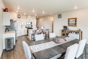 A modern kitchen with white cabinets, a stainless steel refrigerator, and a microwave.