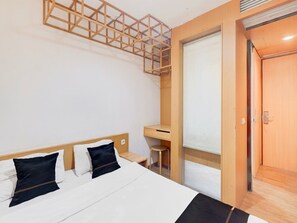 A hotel room with a bed, a desk, and a door. - Luxury Deluxe DBL Retreat W/ Free Wifi and Parking (Jakarta)
