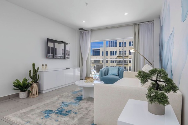 Bright, airy living space with modern touches and a cozy blue accent chair where you can unwind. Natural light fills the room, creating a peaceful retreat after your day of exploring.