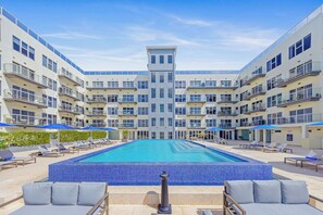 A modern hotel with a central swimming pool surrounded by lounge areas and multiple balconies. - HH-2Bdr415 - Aruba's Amazing 2BDR Retreat. (Oranjestad)
