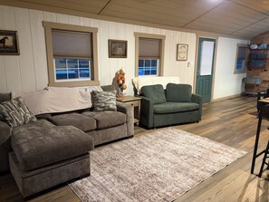 A furnished living room with two sofas, a rug, and a decorative item on a side table. - Brand new to rental market!! Smith River retreat, Riverfront cottage (Stuart)