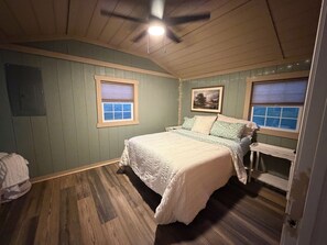 A bedroom with a bed, two windows, a ceiling fan, and a wooden floor. - Brand new to rental market!! Smith River retreat, Riverfront cottage (Stuart)