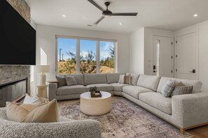 Ein modernes Wohnzimmer mit einem Ecksofa, einem runden Couchtisch und einem Kamin.