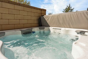 Ein Whirlpool mit Backsteinwand und überdachtem Bereich.