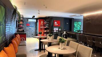A modern interior with seating areas, tables, and a Coca-Cola branded refrigerator.