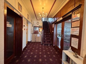 Ein Hotelgang mit Teppichboden, einer Treppe und Schildern, die Privatbereiche und den Parkplatz kennzeichnen.