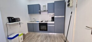 A compact kitchen with grey cabinets, a built-in oven, a coffee maker, and a sink. - Enjoy a comfortable stay in this modern 1-bedroom apartment in Sliema, Malta. Featuring a spacious living area, private bedroom, equipped kitchen and bathroom, it is an ideal base for couples, solo travellers or business stays. (Tas-Sliema)