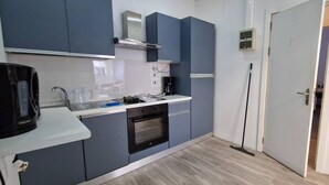 A compact kitchen with a built-in oven, a coffee maker, and a kettle on the counter. - Enjoy a comfortable stay in this modern 1-bedroom apartment in Sliema, Malta. Featuring a spacious living area, private bedroom, equipped kitchen and bathroom, it is an ideal base for couples, solo travellers or business stays. (Tas-Sliema)