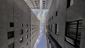 A corridor between two high-rise buildings with a clear sky above. - Staroot - The Velvet Stay (Nairobi)
