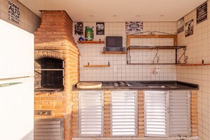 Eine Küche mit Backofen, Kühlschrank und Gasherd.