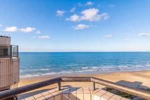 Ein Balkon mit Blick auf das Meer und einen Sandstrand.