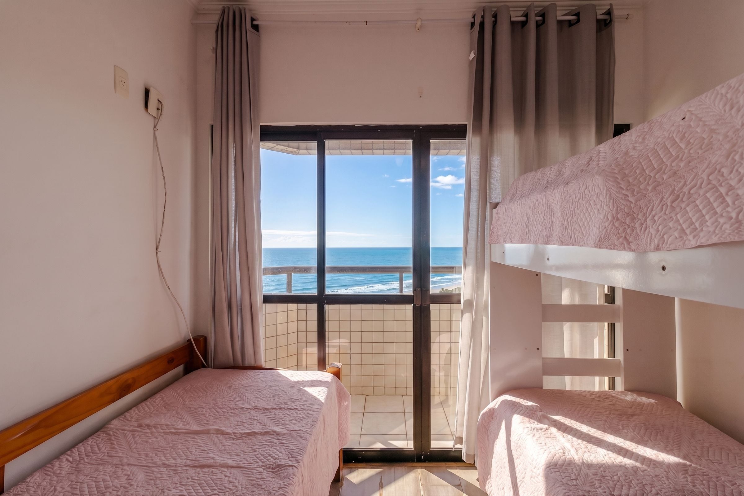 Ein Zimmer mit zwei Etagenbetten, Meerblick und Fliesenboden.