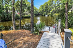 A wooden dock leading to a calm river surrounded by dense trees. - Huge Home, includes Bikes, Kayaks, Private Pool, Game Room, Dock... (Hilton Head Island)