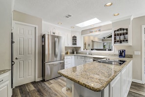 A modern kitchen with a central island, built-in appliances, and a skylight. - Huge Home, includes Bikes, Kayaks, Private Pool, Game Room, Dock... (Hilton Head Island)