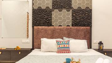 Una habitación de hotel con una cama, una mesita de noche, una lámpara y un panel decorativo en la pared.