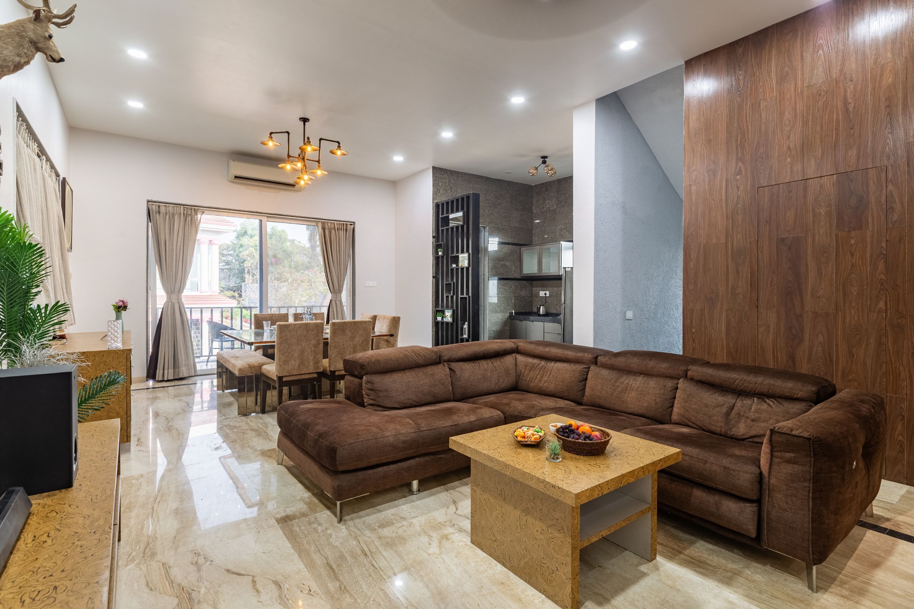 Una sala de estar moderna con un sofá modular, una mesa de centro de madera y un comedor con sillas y una mesa.