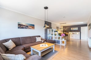 Ein modernes Wohnzimmer mit Sofa, Couchtisch und Pendelleuchten.