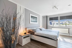 Ein modernes Schlafzimmer mit Bett, Nachttisch und einem Fenster mit Jalousien.