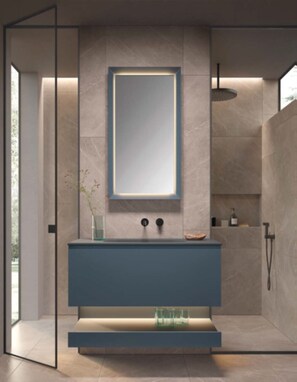 A modern bathroom with a large mirror, a blue vanity, and a shower area. - Superior Apartment # A7 with 2 bedrooms and sauna (Söll)
