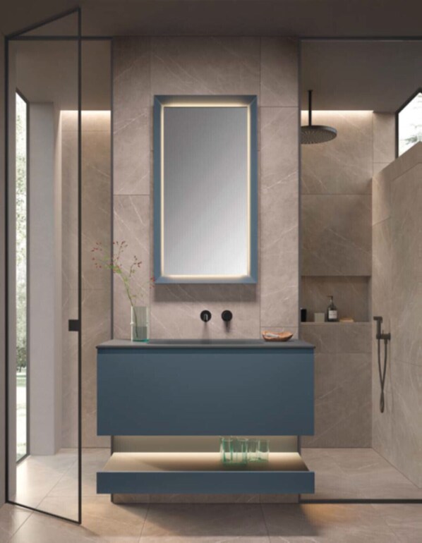 Un bagno moderno con uno specchio grande, un mobile lavabo blu e una zona doccia.