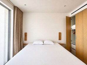 A modern bedroom with a large bed, wooden wardrobe, and a window with curtains. - Villa Epicurean Retreat - Luxurious villa, infinity pool, sea view in Finikounda (Finikounda)