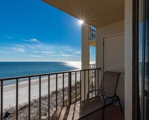 Een balkon met uitzicht op het strand en de oceaan.