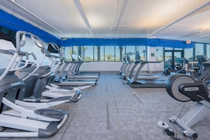 Ein Fitnessraum mit mehreren Laufbändern, Crosstrainern und verschiedenen anderen Cardiogeräten.