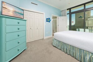 Une chambre à coucher avec un lit, une commode, un placard et une fenêtre donnant sur un beau paysage.