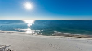 A beach with a clear sky and the sun shining. - Phoenix West 1701 4 Bedroom Condo (Orange Beach)