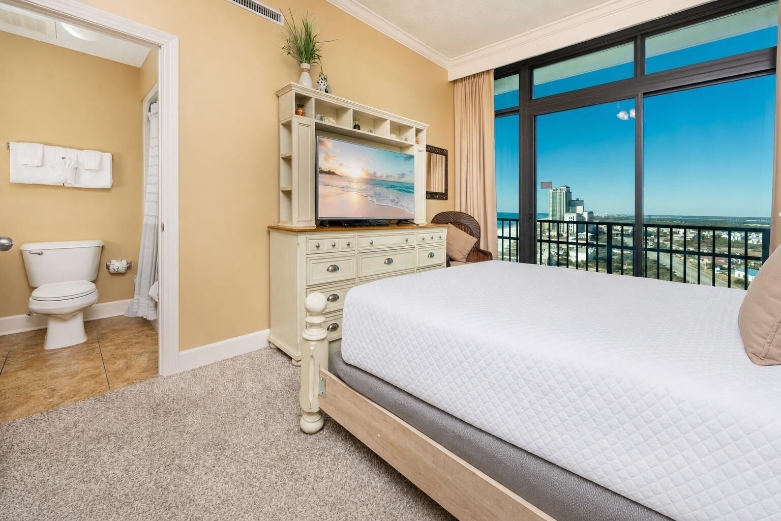 Una camera d'albergo con un letto grande, una televisione, un comodino e vista sulla città.