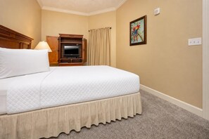 A hotel room with a bed, a television, a painting, and a carpeted floor. - Phoenix West 1006 3 Bedroom Condo (Orange Beach)