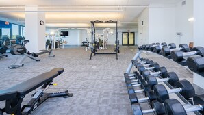 A gym with various exercise equipment, including dumbbells, benches, and weight machines. - Phoenix West 1006 3 Bedroom Condo (Orange Beach)