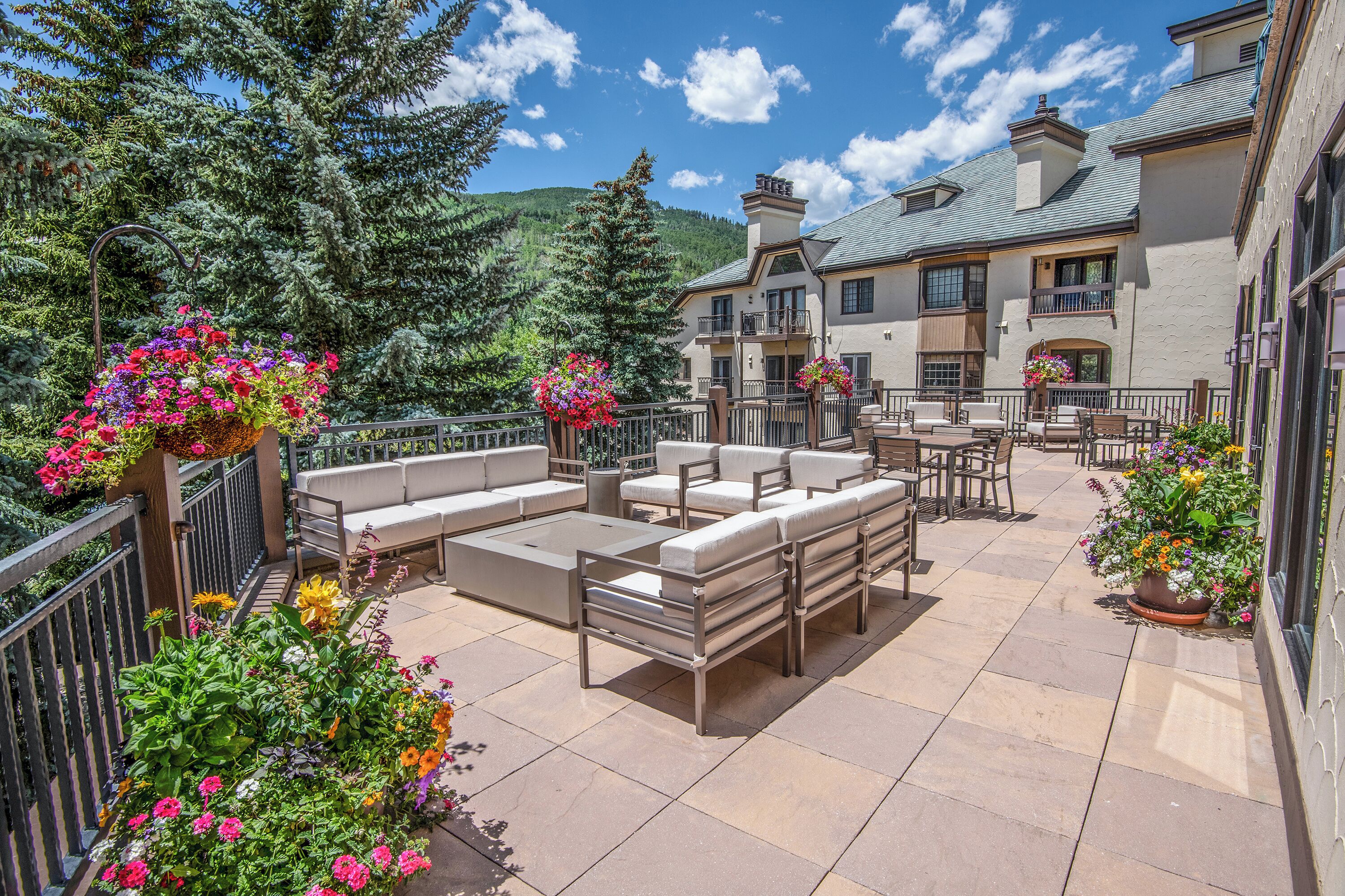 A patio area with outdoor seating and flower planters.