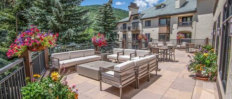A patio area with outdoor seating and flower planters.
