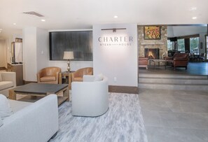 A modern living room with a fireplace, leather chairs, a coffee table, and a stone accent wall. - Ski-In/Out Beaver Creek Condo w/Amenities (Beaver Creek)