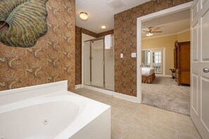 A bathroom with a bathtub, shower, and walk-in closet. - Phoenix West 906 3 Bedroom Condo (Orange Beach)