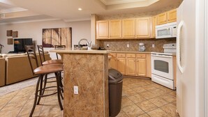 Una cocina con una isla central, armarios de madera, un microondas y un horno.