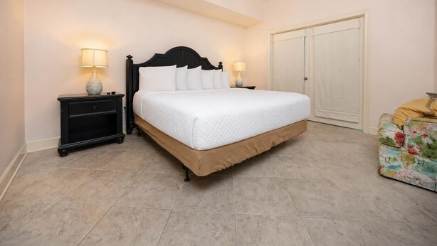 Un dormitorio ordenado con cama, mesitas de noche y un armario.