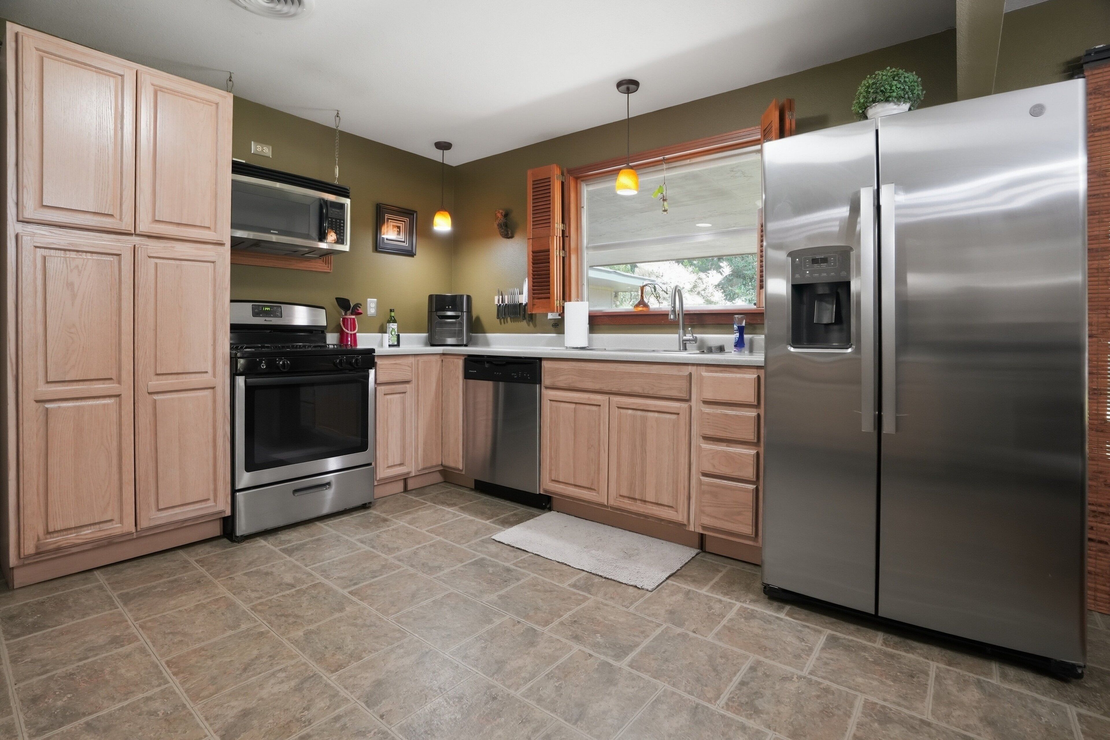 A modern kitchen with wooden cabinets, stainless steel appliances, and a built-in oven.