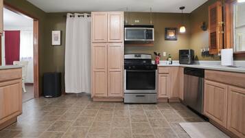 A kitchen with wooden cabinets, a stainless steel oven, a microwave, and a dishwasher.