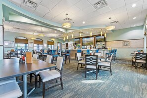 A restaurant with multiple tables and chairs, a bar area, and a large window. - Wex1412 9 Bedroom Home (Davenport)
