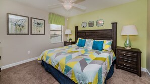 A bedroom with a bed, two nightstands, a ceiling fan, and artwork on the walls. - Wex1410 9 Bedroom Home (Davenport)