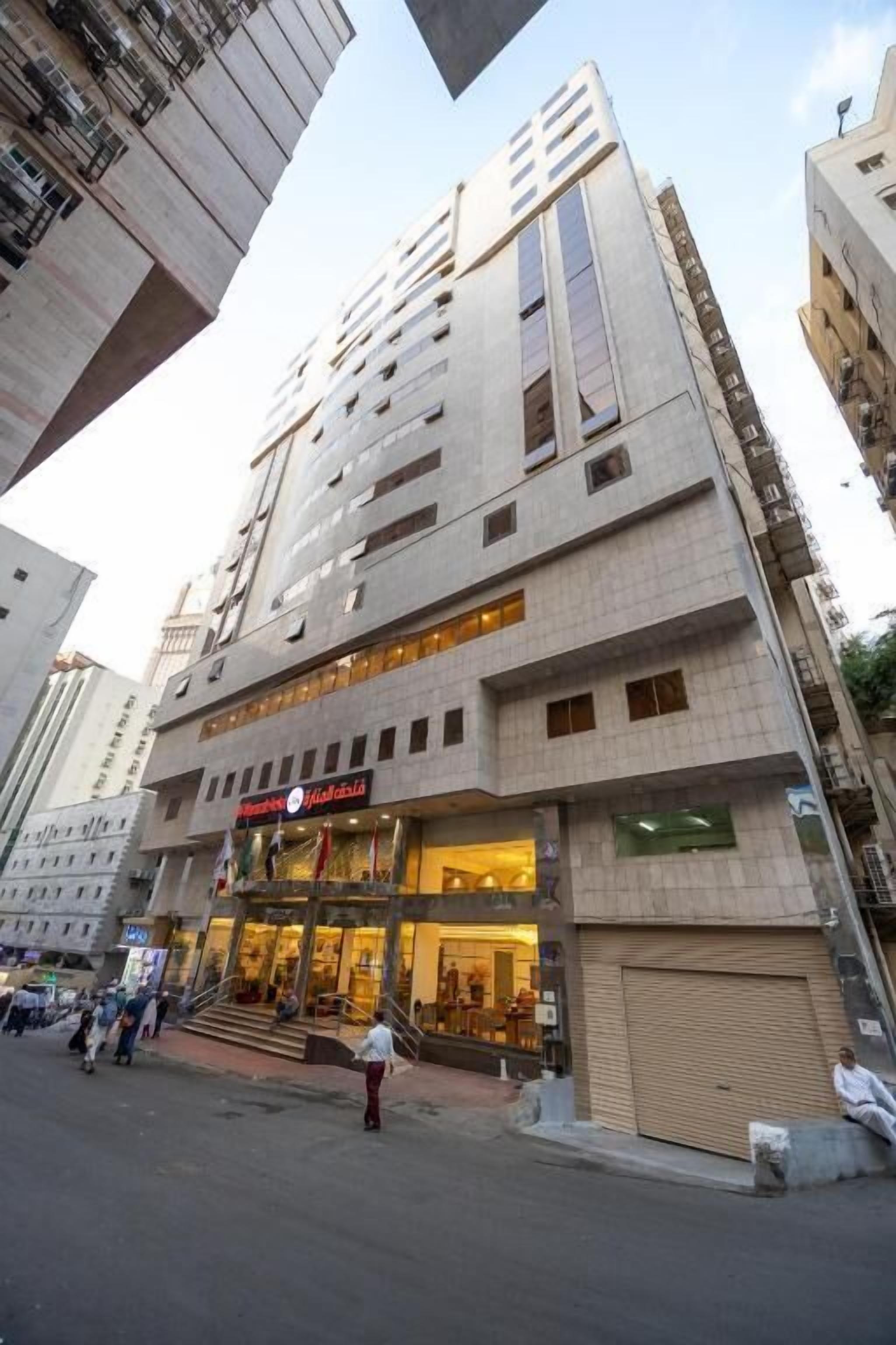 Un immeuble à plusieurs étages dont le rez-de-chaussée est affecté à des activités commerciales, notamment un restaurant et un magasin.
