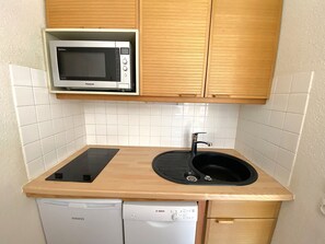 A compact kitchen with a microwave, sink, and dishwasher. - Cozy studio, mountain view - 4 guests (Méribel)