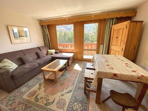 Ein gemütliches Wohnzimmer mit einer Couch, einem Holztisch und einem Teppich mit Muster.